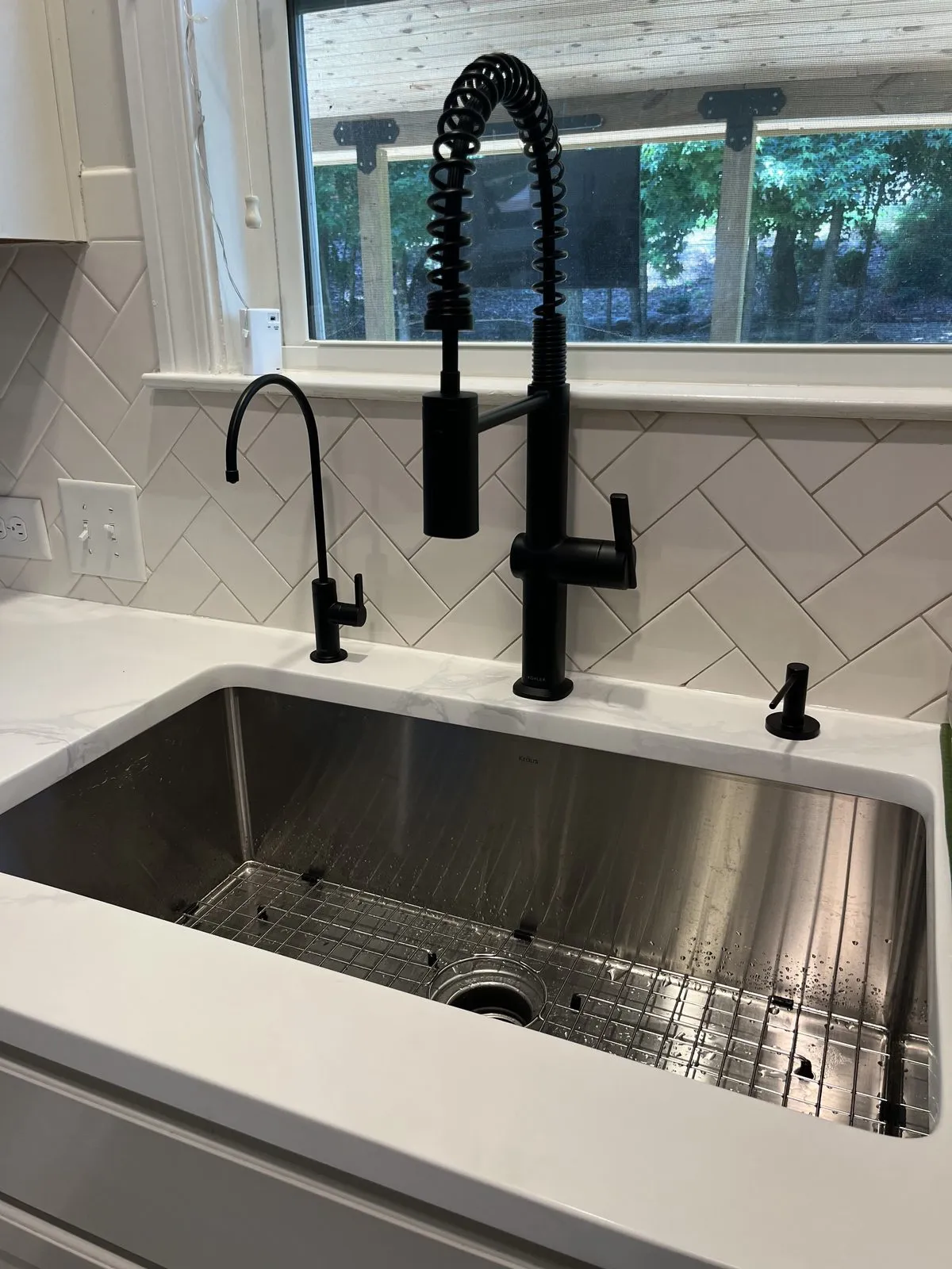 Reverse osmosis drinking-water faucet installed beside the main tap on a kitchen sink